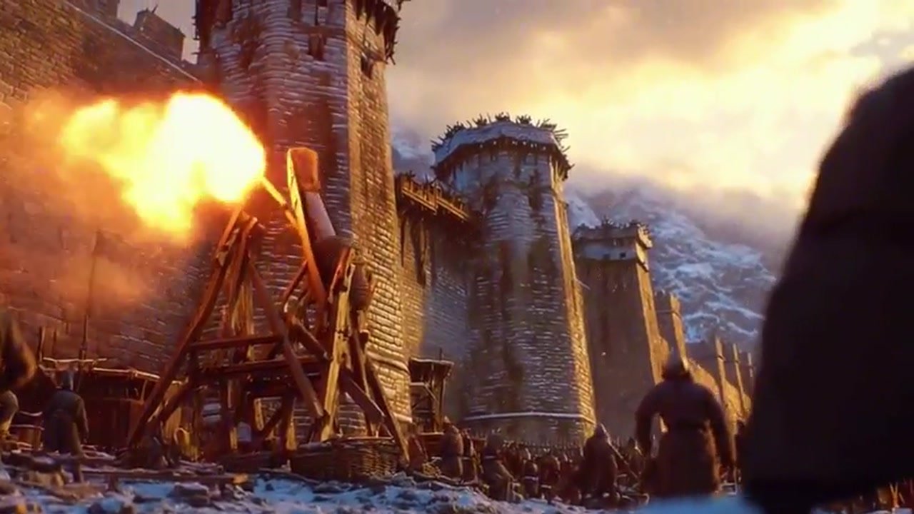 A catapult hurls a fireball at a snowy mountain fortress at sunset